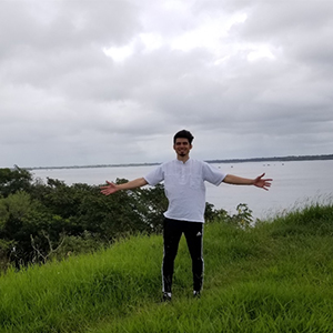 Luis standing with outstretched arms on the southern border of Paraguay and Argentina.