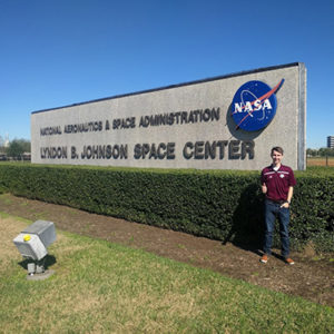 Jake Cooper in front of Johnson Space Center sign