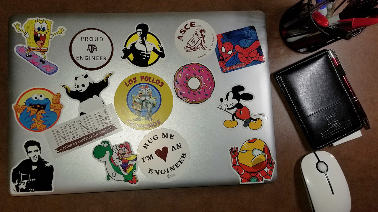 Laptop displaying stickers on the top of it