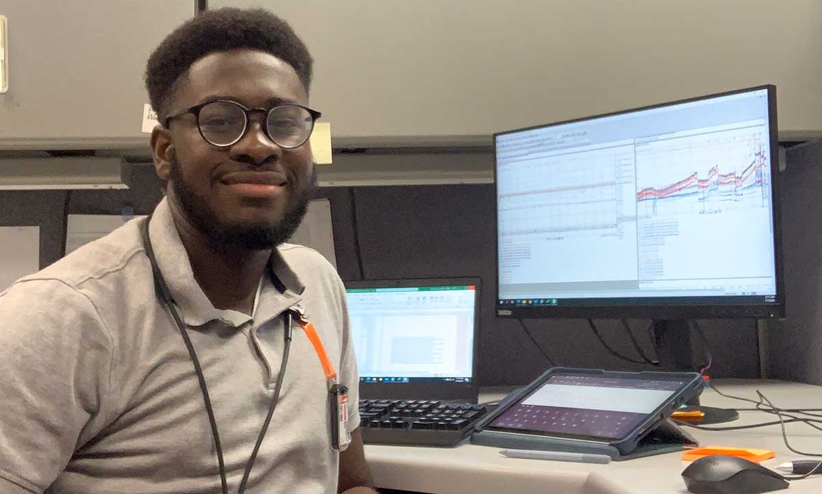 Seun Olumurewa seated at desk with computer during internship at nuclear power plant
