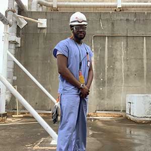 Seun Olumurewa wearing scrubs and safety gear at nuclear power plant