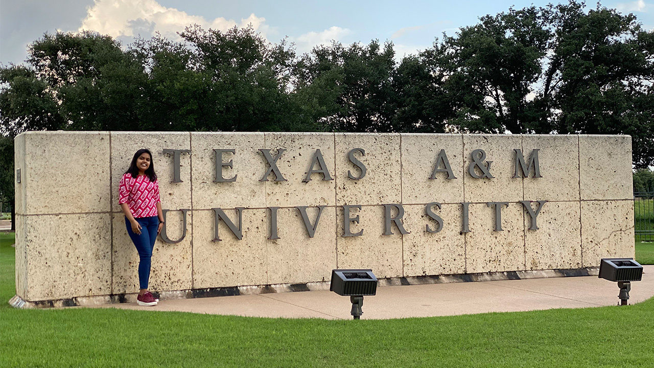 Engineering student, Dakshika Srivastava, standing in front of Texas A&M University sign