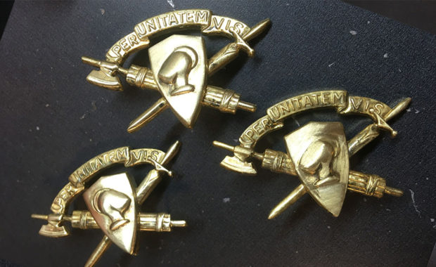 Three Corps of Cadets brass brooches that say "Per Unitatem Vis"