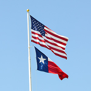The United States flag and Texas state flag on a flag pole