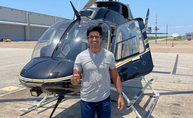Akshaj "Akku" Kumar in front of a helicopter