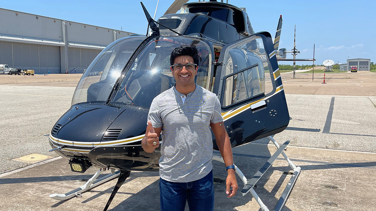 Akshaj "Akku" Kumar in front of a helicopter