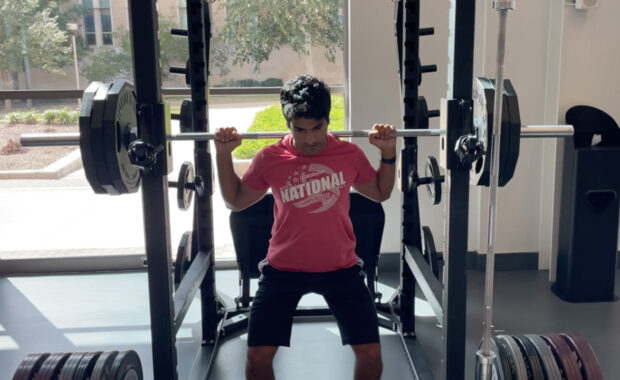 Akku Kumar squatting at the gym