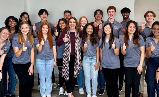 Group photo of EH Edge students smiling, wearing grey polo shirts, displaying thumbs up gesture