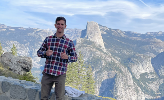 A Texas A&M Engineering Former Student standing in Yosemite National Park with a rocky scene behind.