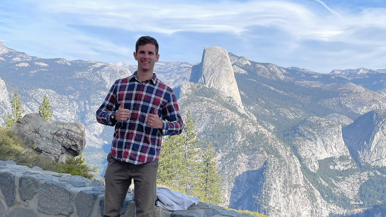 A Texas A&M Engineering Former Student standing in Yosemite National Park with a rocky scene behind.